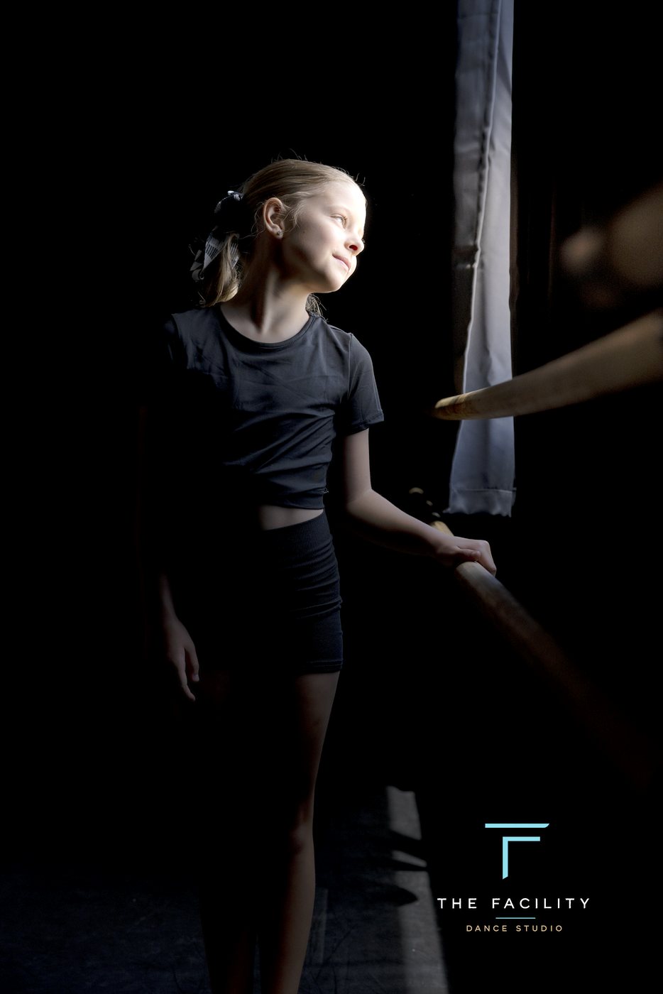 Dancer gazing toward the window at the barre