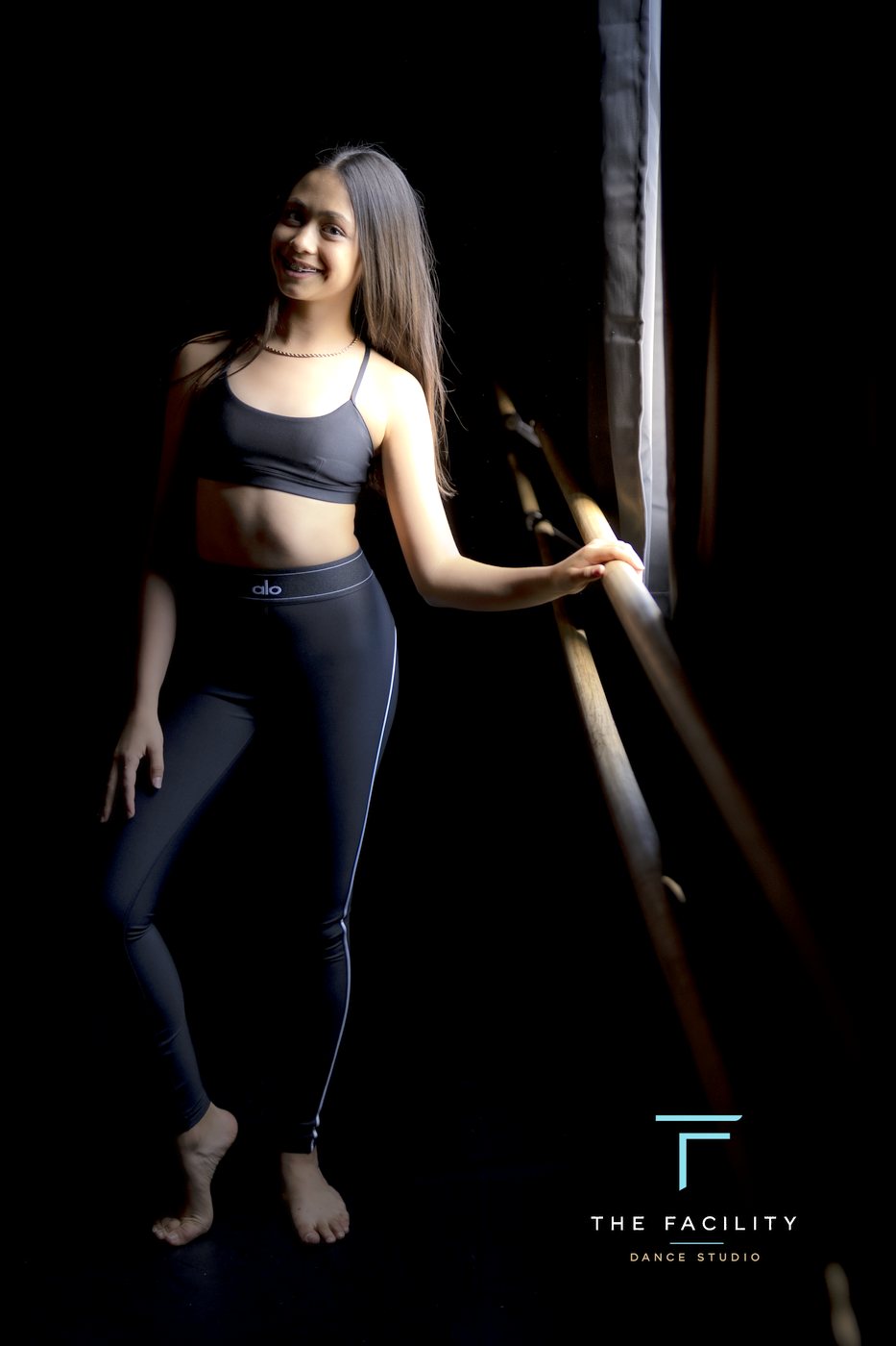 Dancer in leggings poised at the barre